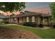 Charming single-story home with covered porch, manicured lawn, and lush landscaping at sunset at 11483 Club Dr, Chapel Hill, NC 27517