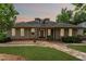 A well-maintained single-story home with a stone walkway, lawn, and mature trees at 11483 Club Dr, Chapel Hill, NC 27517