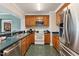 Well-equipped kitchen featuring wood cabinets, stainless steel appliances, and a breakfast bar for casual dining at 11483 Club Dr, Chapel Hill, NC 27517