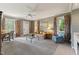 Comfortable living room with a ceiling fan, neutral walls, and large windows offering views at 11483 Club Dr, Chapel Hill, NC 27517