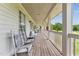 A long, covered porch with rocking chairs and a view of the golf course at 11483 Club Dr, Chapel Hill, NC 27517