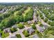 An aerial view showcasing the community's homes, mature trees, and green spaces, including a golf course at 11916 Deneb Ct, Raleigh, NC 27614
