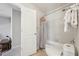 Bathroom featuring a tub with shower, neutral tile, and a doorway leading to another room at 11916 Deneb Ct, Raleigh, NC 27614