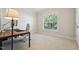 Bright bedroom showcasing a desk, comfortable chair, natural light from the large window, and neutral colored carpet at 11916 Deneb Ct, Raleigh, NC 27614