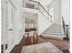 Bright foyer with hardwood floors, staircase with iron railing, and view into a living room with large windows at 11916 Deneb Ct, Raleigh, NC 27614
