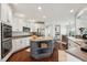 Spacious kitchen boasts an island, stainless steel appliances, ample white cabinetry, and rich hardwood flooring at 11916 Deneb Ct, Raleigh, NC 27614