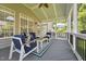 Cozy screened porch with comfortable seating, a ceiling fan, and views of the landscaped backyard at 11916 Deneb Ct, Raleigh, NC 27614