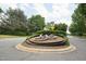 Community entrance sign surrounded by trees, flowers and a street at 11916 Deneb Ct, Raleigh, NC 27614