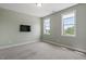 Spacious bedroom with two bright windows and a mounted TV at 12 Beacon Ridge Blvd, Chapel Hill, NC 27516