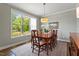 Bright dining room with large window, stylish chandelier, and hardwood floors at 12 Beacon Ridge Blvd, Chapel Hill, NC 27516