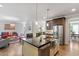 Kitchen island with stainless steel farmhouse sink, stainless appliances, and open layout to the living area at 12 Beacon Ridge Blvd, Chapel Hill, NC 27516