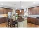 Gourmet kitchen with brown cabinets, island with bar stools, stainless steel appliances, and granite countertops at 12 Beacon Ridge Blvd, Chapel Hill, NC 27516