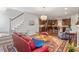 Open living space with kitchen, living room with a fireplace, stairs, and a red sofa at 12 Beacon Ridge Blvd, Chapel Hill, NC 27516