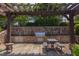 Outdoor kitchen with stainless steel grill, stone wall, pergola, and plenty of space for entertaining at 12 Beacon Ridge Blvd, Chapel Hill, NC 27516
