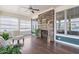 Bright sunroom with stone fireplace, large windows, ceiling fan, and hardwood floors at 12 Beacon Ridge Blvd, Chapel Hill, NC 27516