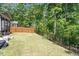 Landscaped backyard with fenced perimeter, lush lawn, and mature trees offering privacy at 12404 Huntley Chase Dr, Durham, NC 27703