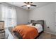 Comfortable bedroom features neutral walls, ceiling fan, and large window with patterned curtains at 12404 Huntley Chase Dr, Durham, NC 27703