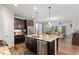 Open-concept kitchen with dark wood cabinets, granite counters, and stainless steel appliances at 12404 Huntley Chase Dr, Durham, NC 27703