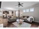 A spacious living room has a decorative ceiling fan, windows, and hardwood floors at 12404 Huntley Chase Dr, Durham, NC 27703