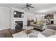 A bright living room features a fireplace, decorative ceiling fan, hardwood floors, and access to the kitchen and dining areas at 12404 Huntley Chase Dr, Durham, NC 27703