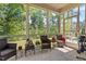 Screened-in patio with outdoor furniture, plants, and views of the green, wooded backyard at 12404 Huntley Chase Dr, Durham, NC 27703