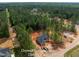An aerial view of a gray home with black shutters surrounded by a dense green forest at 125 Purslane Dr, Franklinton, NC 27525