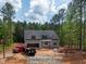Charming home with gray siding, black shutters, an attached garage, surrounded by lush greenery at 125 Purslane Dr, Franklinton, NC 27525