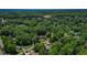 Wide aerial shot of the property surrounded by lush green trees and the neighborhood at 1274 Candlewood Dr, Elon, NC 27244