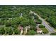 Wide aerial perspective showcasing a suburban neighborhood with mature trees and nearby highway at 1274 Candlewood Dr, Elon, NC 27244