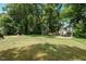 Expansive backyard with mature trees, a fire pit area, a storage shed, and ample space for recreation at 1274 Candlewood Dr, Elon, NC 27244
