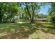 Expansive backyard with mature trees, fire pit area, storage shed, and ample space for recreation at 1274 Candlewood Dr, Elon, NC 27244