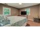 Comfortable bedroom featuring a queen bed, bright windows, and a dark colored side table at 1274 Candlewood Dr, Elon, NC 27244