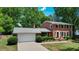 Traditional two-story brick home with attached garage, mature landscaping, and a cozy front entrance at 1274 Candlewood Dr, Elon, NC 27244