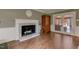 Bright living room showcasing fireplace, wood flooring and French doors to the sunroom at 1274 Candlewood Dr, Elon, NC 27244