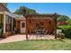 Inviting brick patio with a pergola, perfect for outdoor dining and entertaining with hanging lights at 1274 Candlewood Dr, Elon, NC 27244