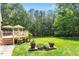 Backyard featuring a covered deck with furniture, green grass, mature trees, and manicured lawn at 1312 Glenden Falls Way, Raleigh, NC 27614