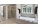 Luxurious bathroom featuring a soaking tub, walk-in shower, and large window at 1312 Glenden Falls Way, Raleigh, NC 27614