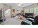 Spacious living room with a leather sofa set, large windows, and a neutral color palette at 1312 Glenden Falls Way, Raleigh, NC 27614