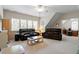 Spacious living room with plush couches, ceiling fan, and large windows offering plenty of natural light at 1312 Glenden Falls Way, Raleigh, NC 27614
