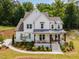 Beautiful two-story home boasts a covered porch, lush landscaping, and sleek white siding for curb appeal at 1344 Legend Oaks Drive Dr, Chapel Hill, NC 27517