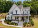 Charming two-story home featuring a covered porch, manicured landscaping, and modern white siding at 1344 Legend Oaks Drive Dr, Chapel Hill, NC 27517