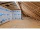 A spacious unfinished attic with exposed beams and a door that could be converted into living space at 1430 Clifton Pond Rd, Louisburg, NC 27549