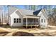 Backyard showcasing the screen porch with views of the trees and outdoor features at 1430 Clifton Pond Rd, Louisburg, NC 27549