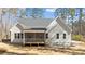 The backyard shows off the large screened-in porch, siding, windows, and deck with steps at 1430 Clifton Pond Rd, Louisburg, NC 27549