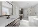 Bright bathroom featuring double vanities, a soaking tub, and a glass enclosed shower at 1430 Clifton Pond Rd, Louisburg, NC 27549
