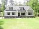 Beautiful home with gray paint, black shutters, and a lush green lawn surrounded by mature trees at 1430 Clifton Pond Rd, Louisburg, NC 27549