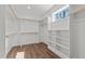 Walk-in closet with built-in shelving and wooden rods for hanging clothes at 1430 Clifton Pond Rd, Louisburg, NC 27549