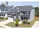 Gorgeous aerial view of a two-story home showcasing the manicured lawn, landscaping, and neighborhood at 155 Annabelle Branch Ln, Apex, NC 27523