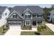 Aerial shot of a beautiful two-story home with a stone-accented garage and a landscaped front yard at 155 Annabelle Branch Ln, Apex, NC 27523