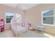Pink bedroom with a decorative canopy bed and bright natural light from two windows at 155 Annabelle Branch Ln, Apex, NC 27523